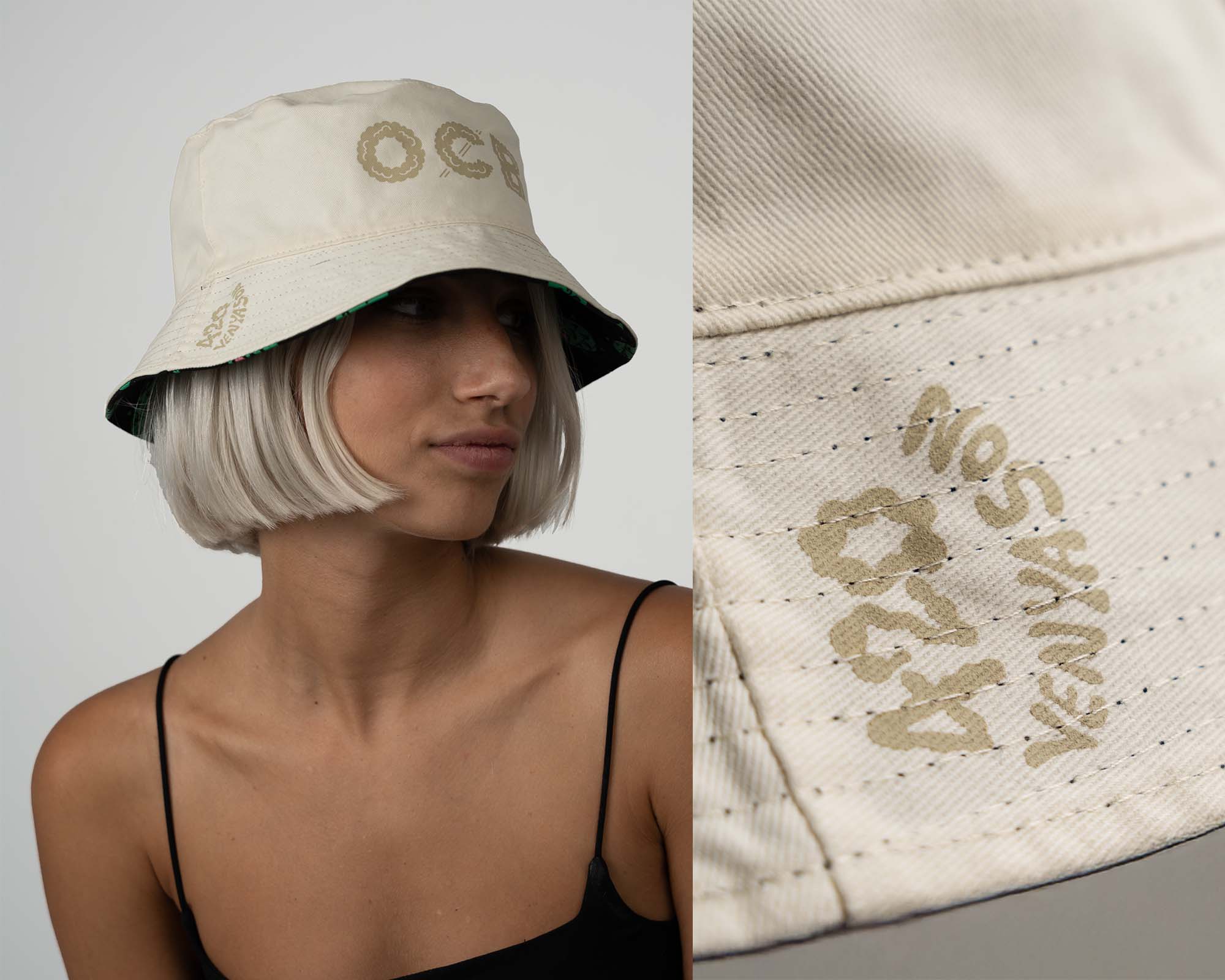 Person wearing a beige bucket hat with gold text, close-up of text on the hat.